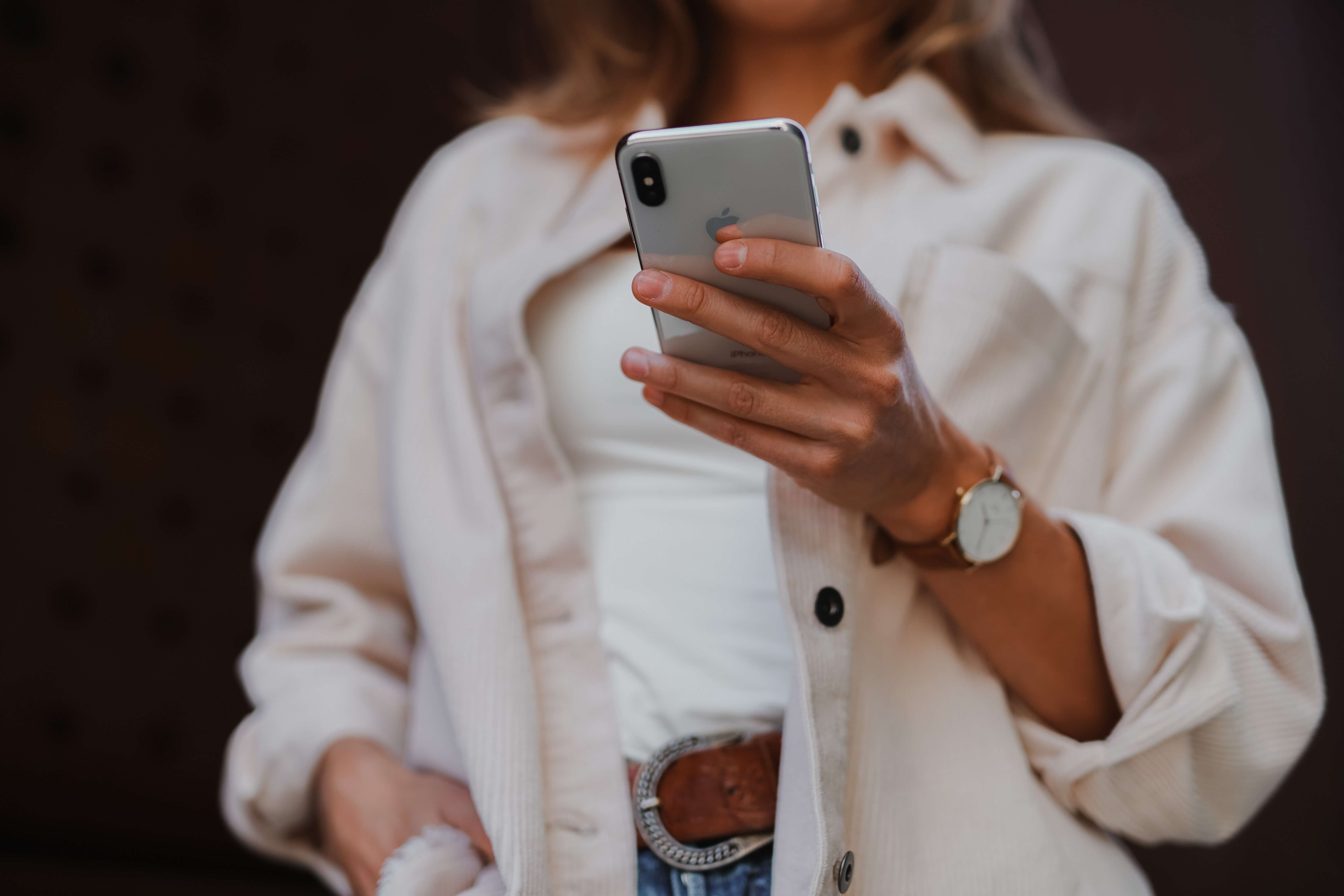 A young woman holding her iPhone